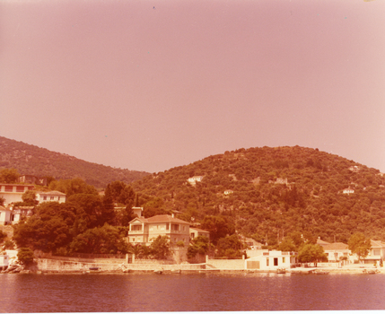 A port-side village with mountains in the background.