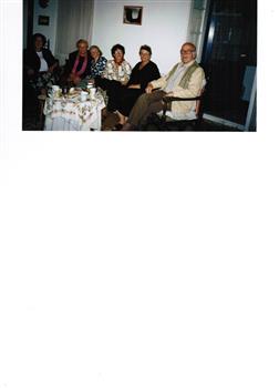 Six people enjoying refreshments in a house.