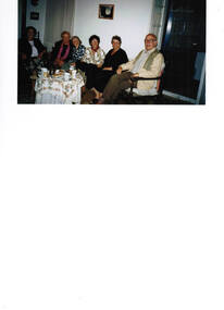 Six people enjoying refreshments in a house.