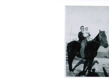 A young boy holding an infant child on a horse.