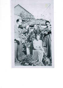 Three men and a lady in a garden.