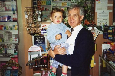 Photograph, Dennis Varigos in his pharmacy