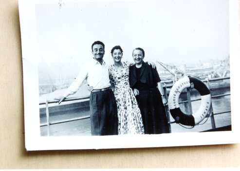 Two ladies and a man on the deck of a ship.