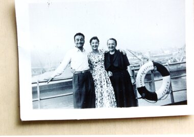 Two ladies and a man on the deck of a ship.