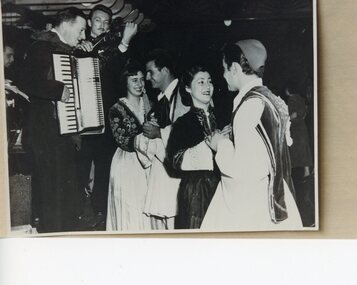 Two couples in Greek costume dancing.