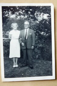 A lady and man standing in a garden.