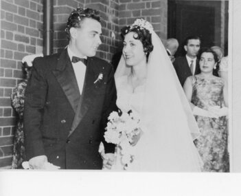 A bridal couple standing at the church doors.