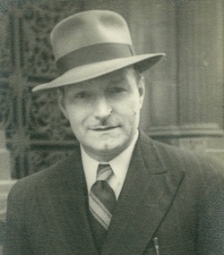 A head and shoulders image of a smartly dressed man who is wearing Stetson Hat.
