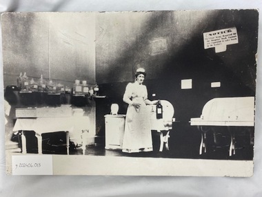 Photograph of nurse in nurses uniform standing in the Operating theatres- circa 1900