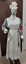 Picture of uniform worn circa 1900's nurses uniform on mannequin. Uniform includes; mop cap, checked long sleeved dress, white ankle length starched apron, detachable collar and cuffs and belt with keys hanging from belt. Shoulder has badge with white background and filled in red cross. Rear of uniform apron straps crossed and buttoned at the waist.