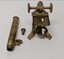 Photograph of a Brass and glass microscope made of 3 parts consisting of a Brass body, eye piece and eye piece adaptor. Photo shows 3 separate pieces.
