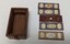 Photograph of a Brass and glass microscope slides, including small wooden storage box. The photo shows 4 glass slides with patterns on them, and the wooden box and separate lid.