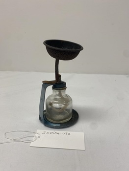 Metal stand containing glass bottle with a wick in the lid. Used to vaporise and deliver medication to patients.