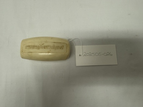 Degraded white plastic case with writing embossed on lid 