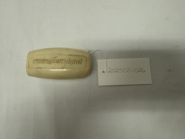 Degraded white plastic case with writing embossed on lid and label