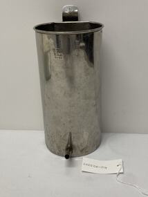 Monometal cylindrical enema can. Rounded for 2/3rd and flat back with tag with hole in it at the top and nozzle at bottom of can to attach enema tubing to. Top edge (lip) of opening is rounded.
Enema can used to administer enemas to patients.