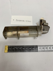 silver metal holder with bracket that attaches to the bed frame with plastic (not original) tube to hold mercury thermometer. Mercury thermometer reads 35 - 42oC