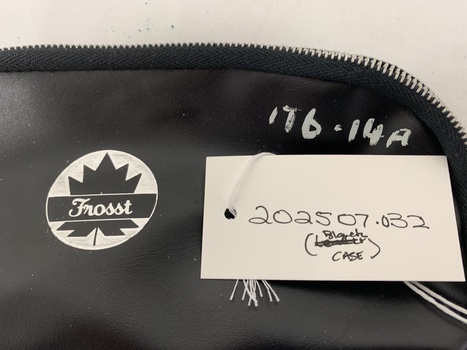 black vinyl case with central logo - white circle with black maple leaf, banner across centre with script "Frosst"