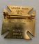A gold cross-shaped medal with the inscription "Louisa Mann Medal for General Proficiency in Nursing, Awarded to Alfred Hospital Nurses League.