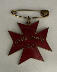 A red enamel badge in the shape of a star, reading "ALFRED HOSPITAL 1914," attached to a safety pin.