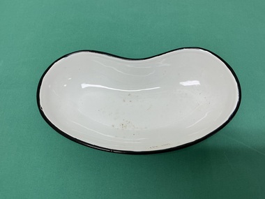 Small white kidney-shaped ceramic dish with a black rim.