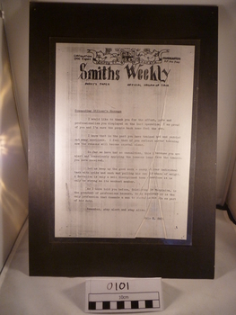 A laminated paper on black paper about a commanding officer message on Smiths Weekly. 