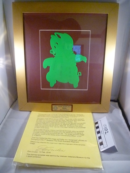 A green pig facing left on a crimson background with golden border.