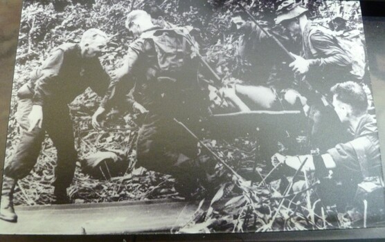 A Black and White Photograph of of an Injured Soldier Being Stretched Out