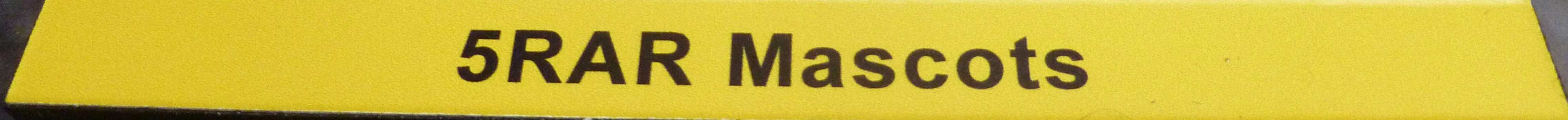 A yellow board with black texts "5RAR Mascots"