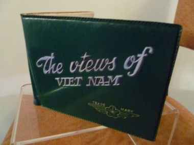 Dark green plastic mini photo album with each plastic sleeve page containing just one black and white photo of Vietnam.