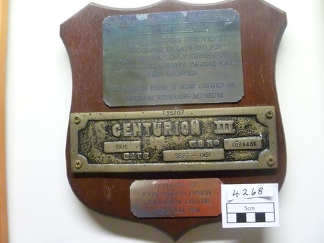 A wooden plaque with three metal plates.
