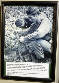 A Black and White Photograph of Two Soldiers Filling Water Bags