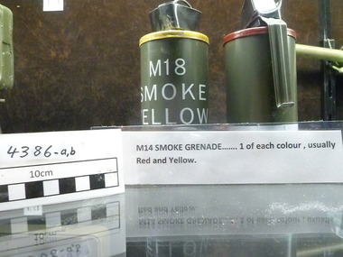 Two smoke cannister, one with yellow top and one with red top. Yellow one has the words M18/Smoke/Yellow