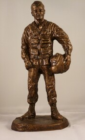 Statue of airman in flying uniform holding helmet under right arm