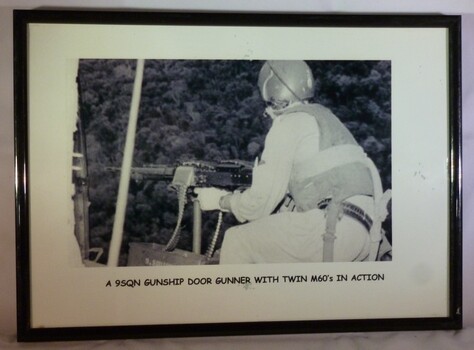 A Framed Black and White Photograph of A 9SQN Gunship Door Gunner With Twin M60's In Action