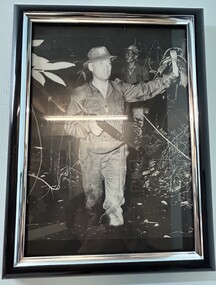 A Black and White Photograph of a Solder Carrying His Weapon.