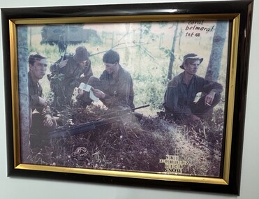 A Framed Coloured Photograph of Four Soldiers Squatting on the Ground