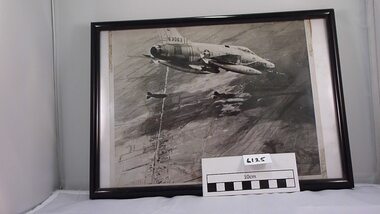 Black and white photograph in black frame depicting USAF Phantom 63063 dropping bombs.