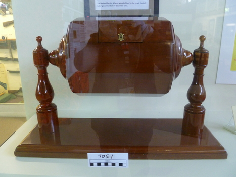 The octagonal fiddle-back cedar barrel is held by two supports base on one side of barel.