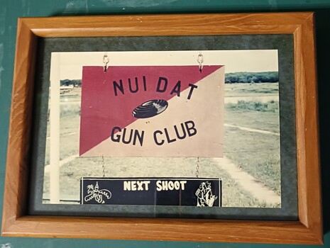 Small coloured phott of a sign with the word Nui Dat Gun  Club