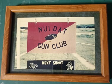 Small coloured phott of a sign with the word Nui Dat Gun  Club