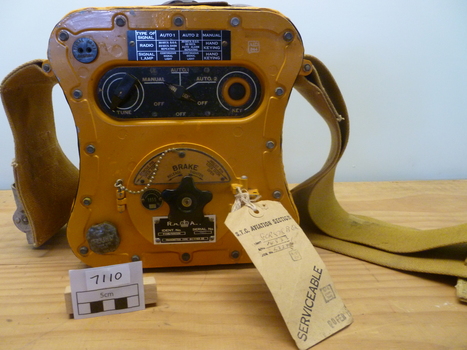 Squat yellow transmitter used in emergency life rafts carried by aircraft on flights over water. Shape enabled it to be held between knees. 