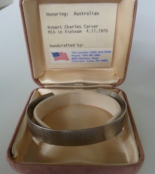 Stainless steel open-ended bracelet engraved with missing serviceman's full name and date missing.