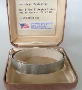 Stainless steel open-ended bracelet engraved with missing serviceman's full name and date missing. In a buff square velvet satin-lined box.