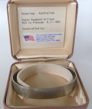 Stainless steel open-ended bracelet engraved with missing serviceman's full name and date missing. In a buff square velvet satin-lined box.