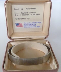 Stainless steel open-ended bracelet engraved with missing serviceman's full name and date missing. In a buff square velvet satin-lined box.
