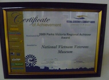 Black plastic frame with gold trim with an award from Regional Achievement & Community Awards