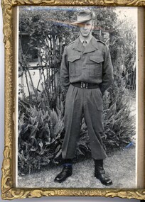 A framed photograph of Private Errol Noack in uniform in front of a garden taken at his home in Adelaide his deployment to Vietnam.