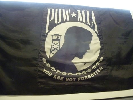 Black nylon banner with white print of circle with silhouette of guard tower