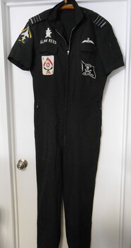 A black one piece Dining Suit (party suit)  with zippered front and pockets, bearing Squadron Leader epaulettes